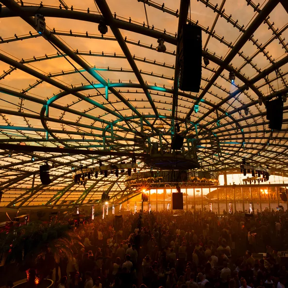 Das Sunset-Event im Red Bull Hangar-7 bei Sonnenuntergang, der die gesamte Halle und das Publikum in goldenes Licht taucht.