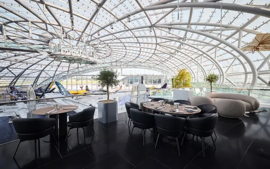 Gedeckte Tische auf der Restaurant Ikarus Terrasse mit Blick in die Austellung