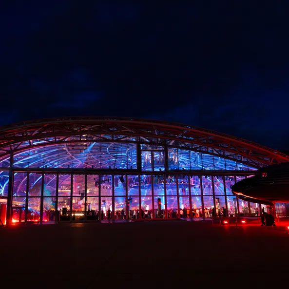 Außenansicht des beleuchteten Red Bull Hangar-7 bei Nacht während des Sunset-Events.